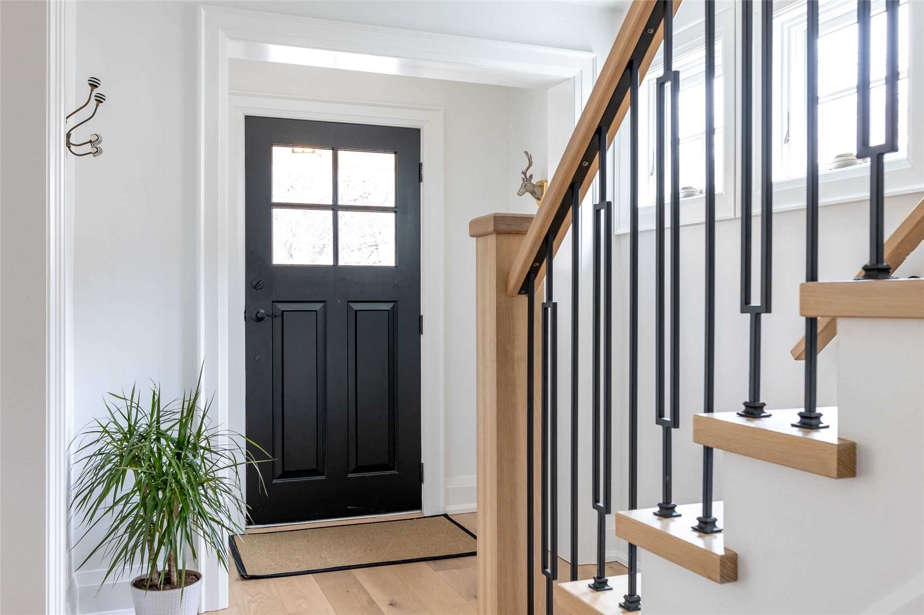 front entrance, stair pickets, staircase, black door, light hardwood, stair post, stair cap, front entry, wrought iron pickets, custom stairs, dining room, Scandinavian, modern, custom art