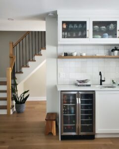 floating shelf, artisan tile, white oak floors, wrought iron picket, brizo, franke, glass cabinets, bar fridge, kitchen stool, snake plant, gold hardware, quartz countertop, white kitchen, prep sink, beverage faucet